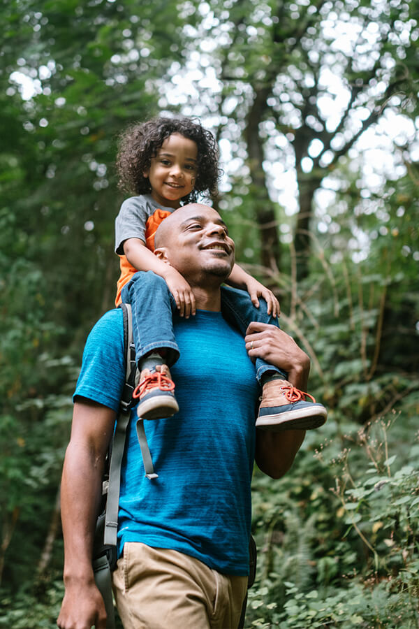 Boy on dad's shoulders outside