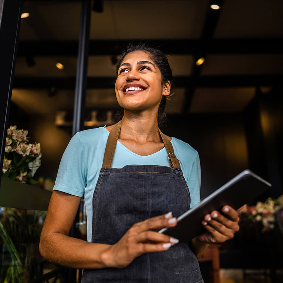 Business owner in smock with tablet