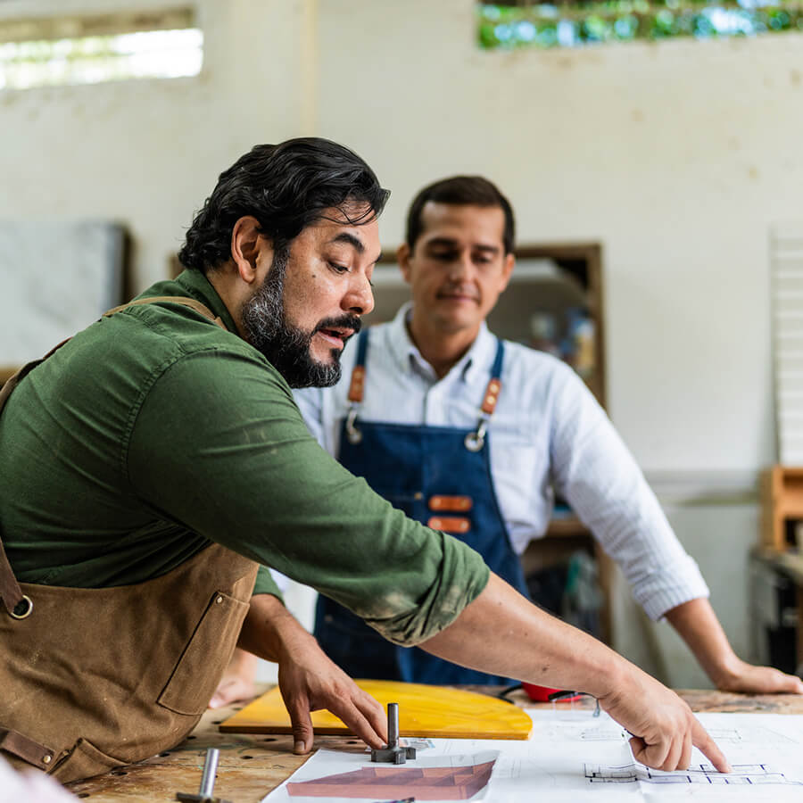 Carpenter explaining diagram to employees