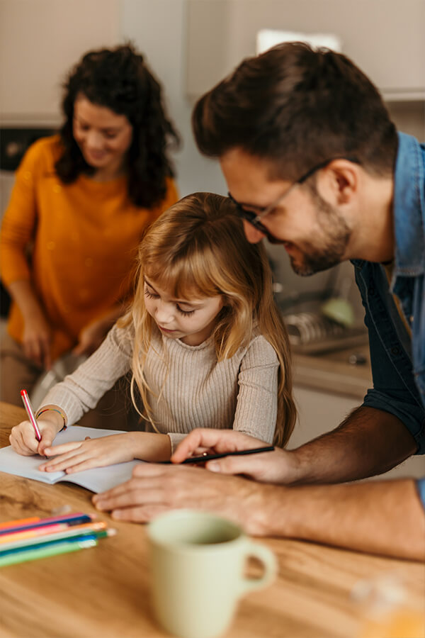 Child using coloring book with parents