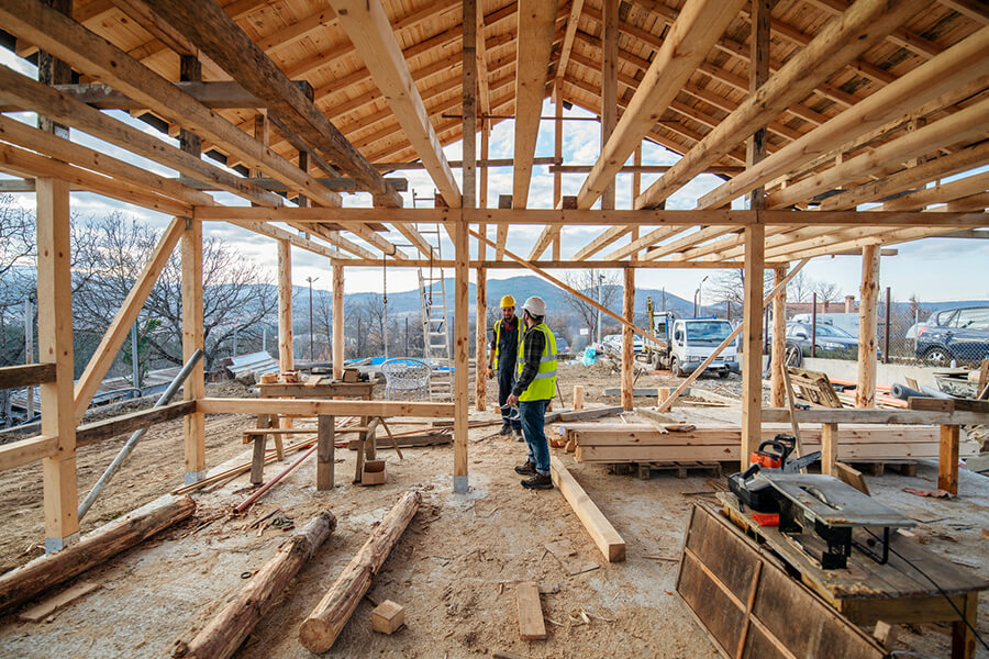 Construction workers in a building with mountains in the background
