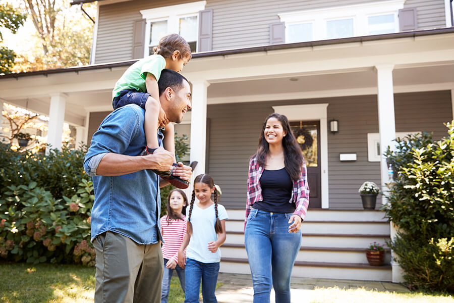 Family standing in front of house