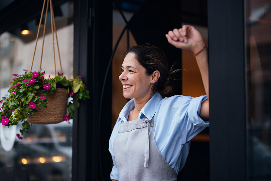 Female business owner in entryway of restaurant