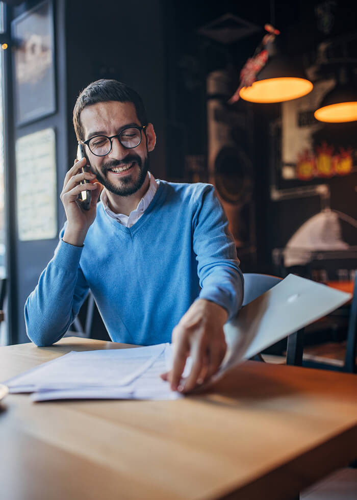 Man at table with phone and papers