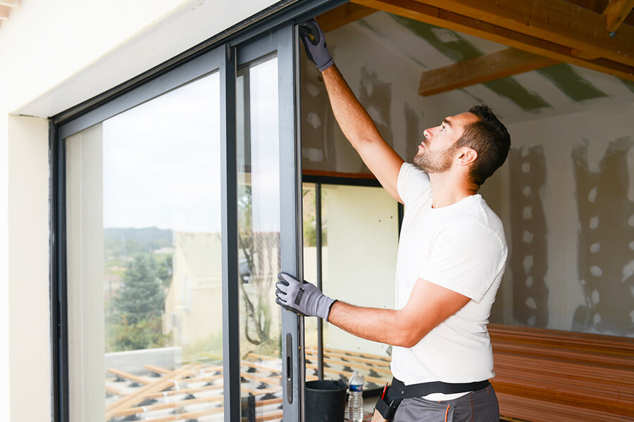 Man installing door into frame