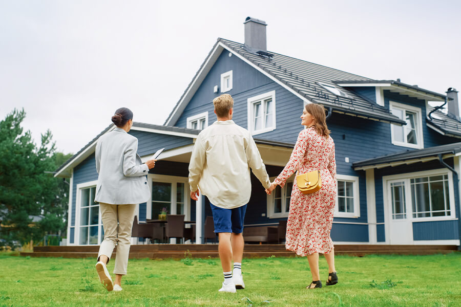 3 people looking at a large house