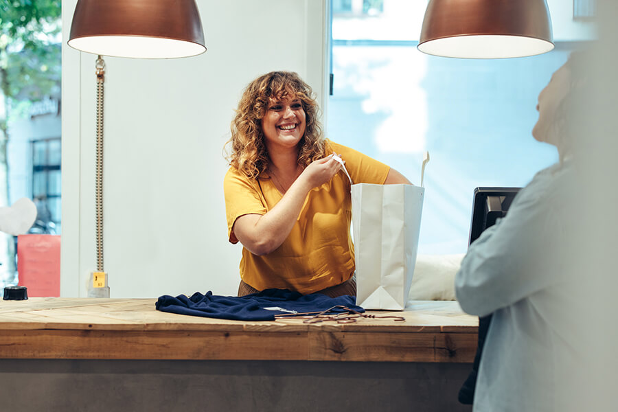 Woman at shop adding clothes to a bag