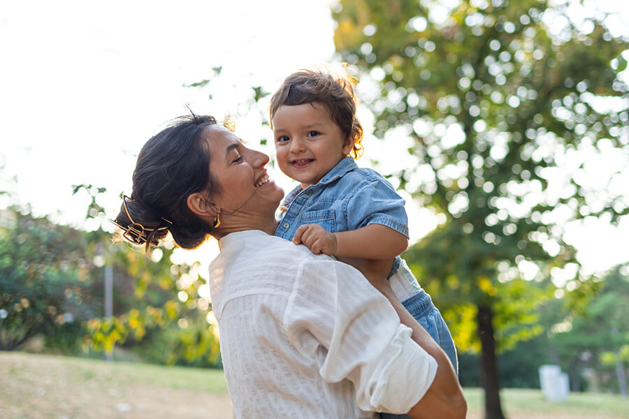 woman holding her son in the park