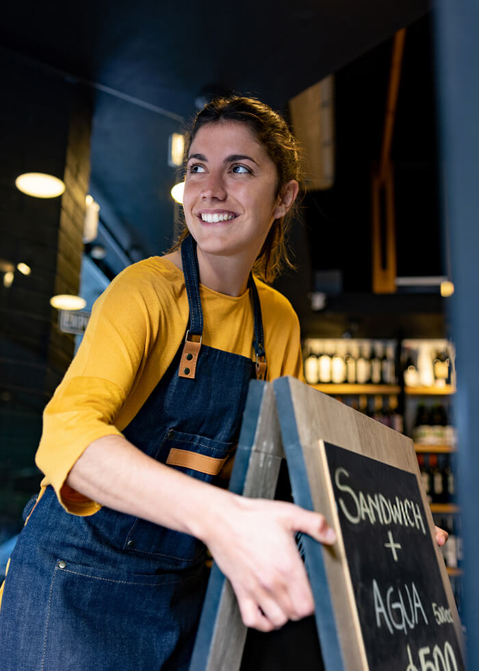 Woman pulling sandwich board out of store