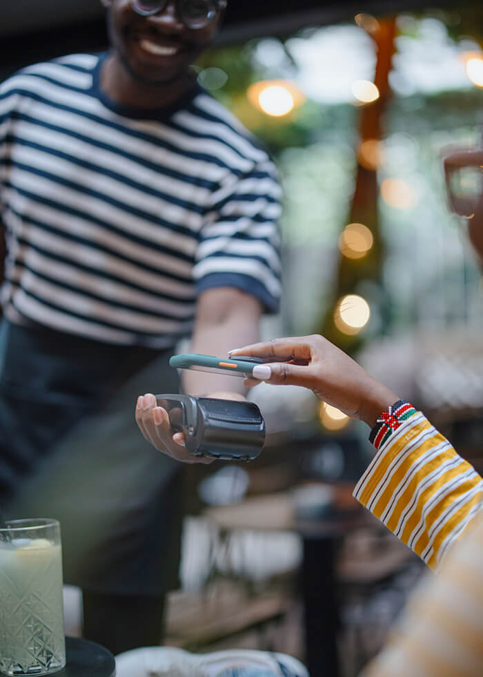 Woman using phone to pay bill at restaurant